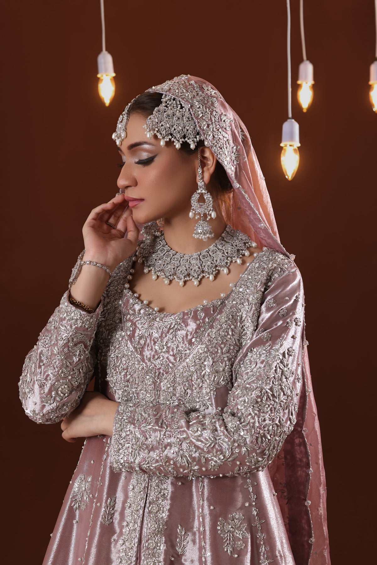 Finished bridal pieces on a wooden rail in a calm, light-filled luxe studio, soft daylight