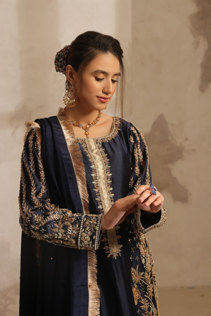 Karigur Dania — midnight-navy Sheesha silk bridal suit with rosegold dabka and gold nakshi embroidery and a gold-tissue-bordered silk dupatta, front view.