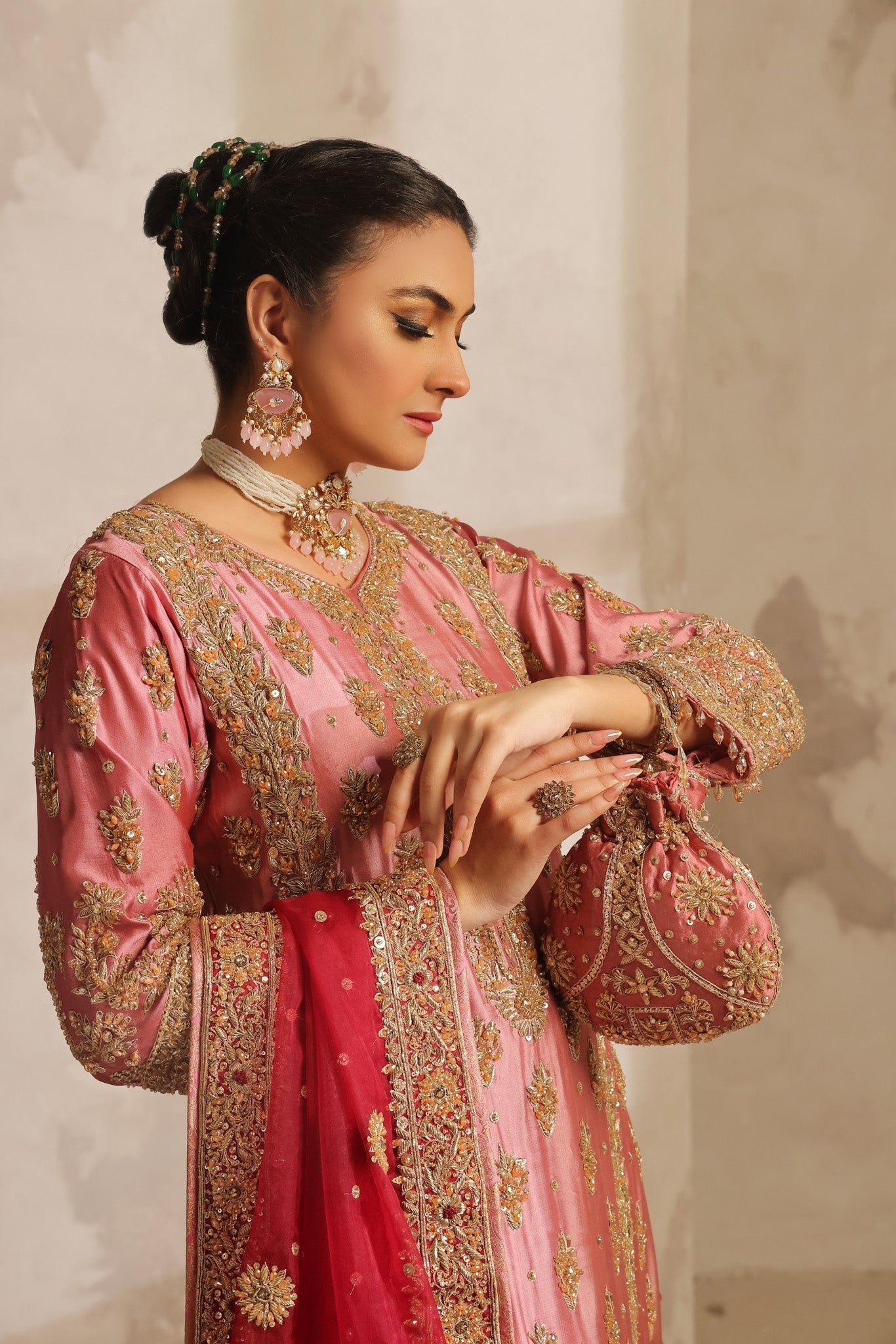 Karigur Nayira — rose-pink silk bridal suit with all-over antique-gold dabka, sequin and resham embroidery, front view.