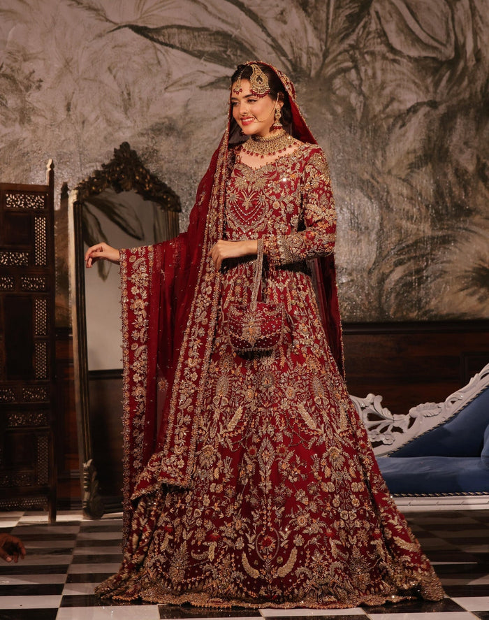 Karigur Ruhani — ruby-red pure-chiffon bridal gown and lehenga with heavy gold zardozi and a head-draped dupatta, front bridal view.