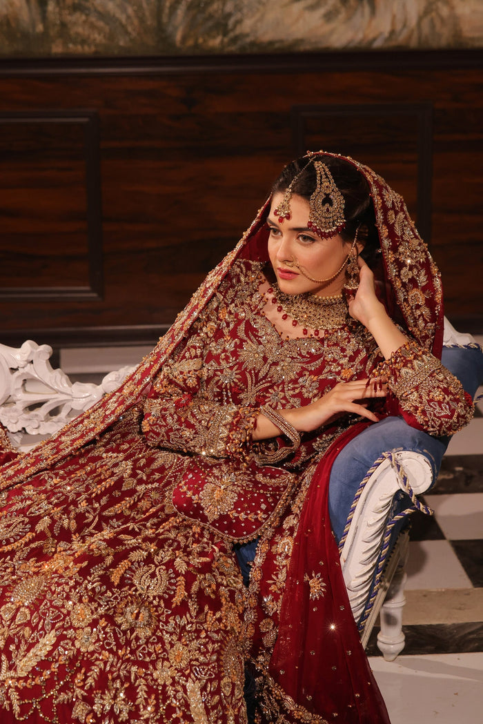 Karigur Ruhani ruby-red bridal gown with a gold embroidered border and embellished belt.