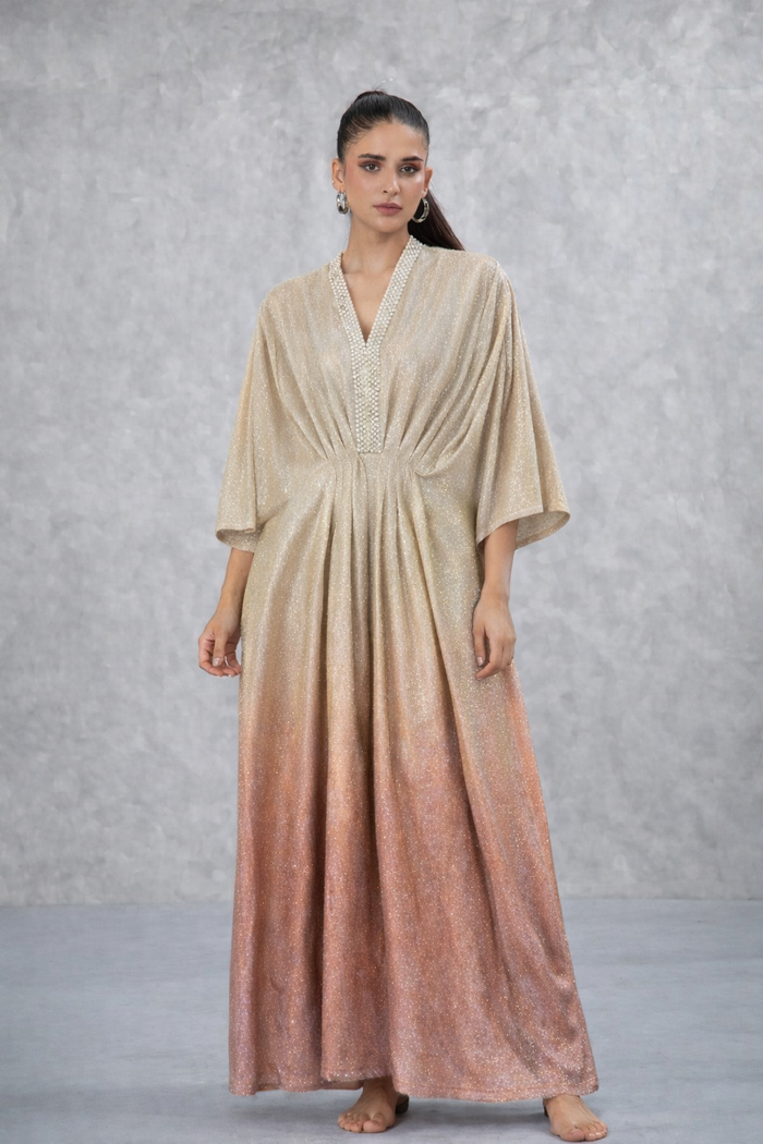 Model in a gold-to-blush ombre kaftan with gathered waist and embellished neckline by Karigur Bridal