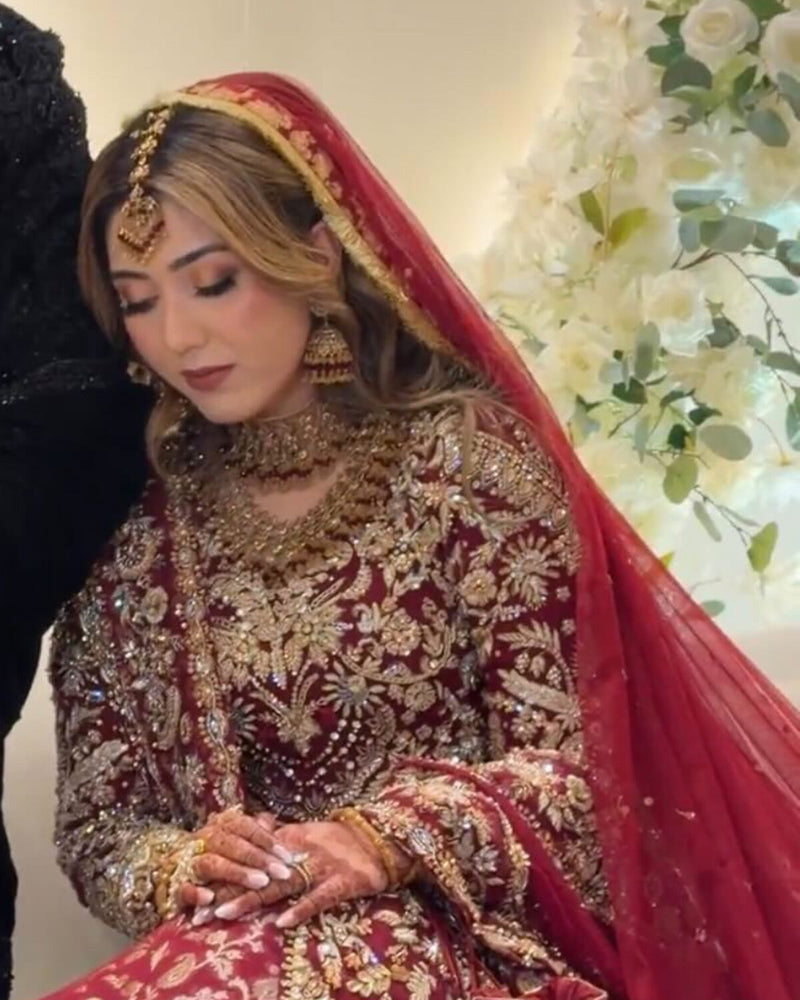Bride in a red and gold farshi bridal lehenga with zardozi embroidery and gold jewellery, by Karigur, Toronto