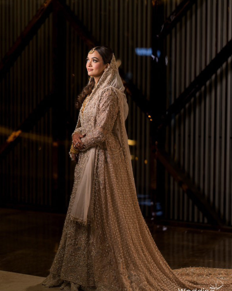 Bride in a champagne and gold hand-embroidered bridal gown with trailing dupatta, by Karigur, Toronto